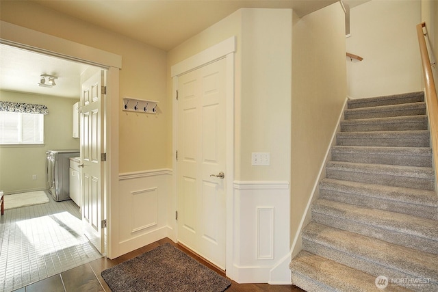 staircase with washing machine and dryer and hardwood / wood-style floors