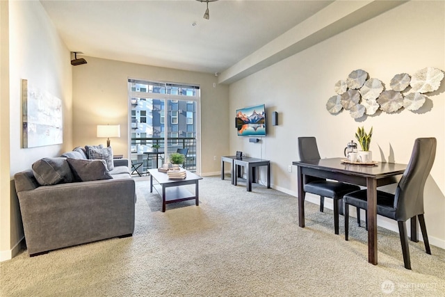 carpeted living area with baseboards