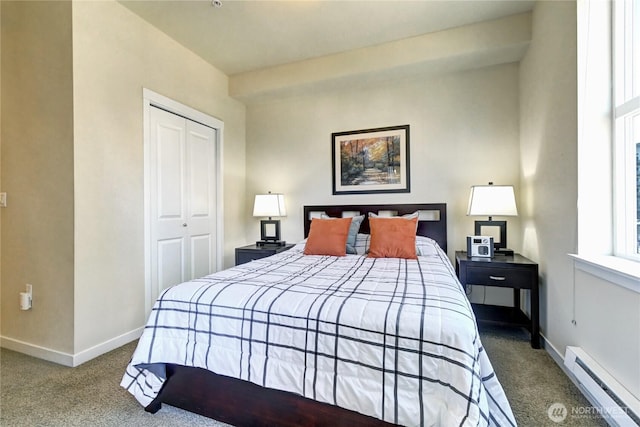 carpeted bedroom with a closet, baseboard heating, and baseboards