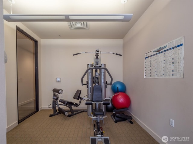 exercise room featuring baseboards and carpet floors