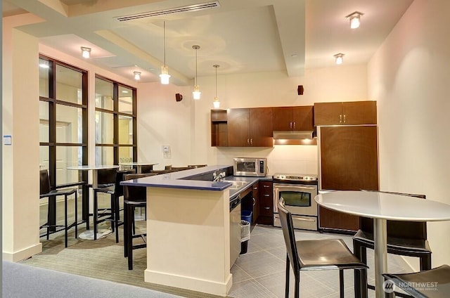 kitchen with visible vents, under cabinet range hood, decorative backsplash, stainless steel range with electric stovetop, and hanging light fixtures