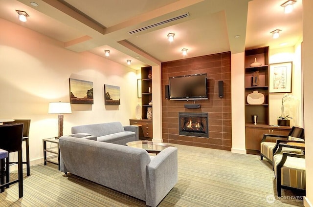 living room featuring visible vents, built in shelves, carpet floors, and a tiled fireplace