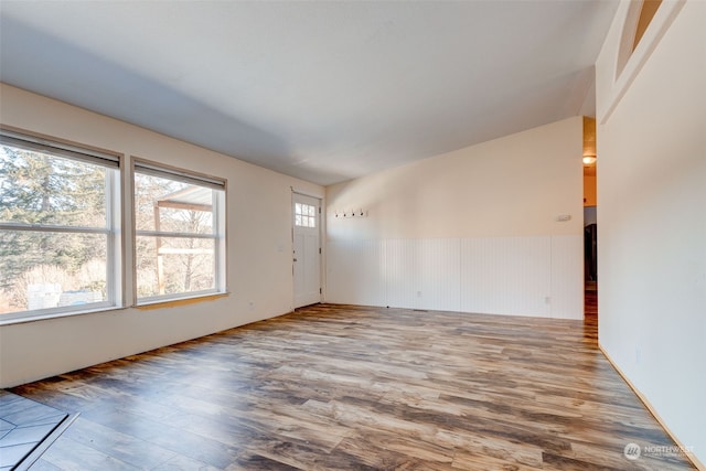 unfurnished room with hardwood / wood-style flooring and vaulted ceiling