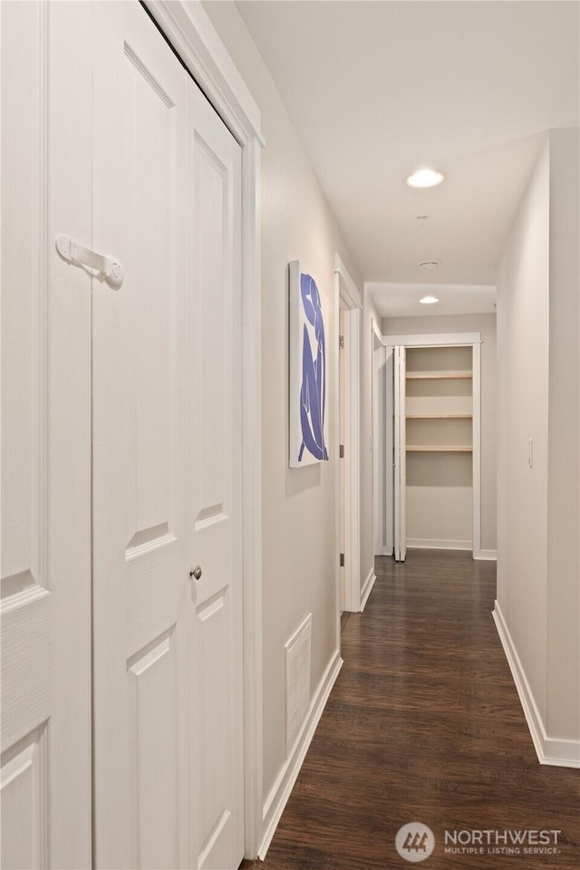 corridor with dark hardwood / wood-style flooring