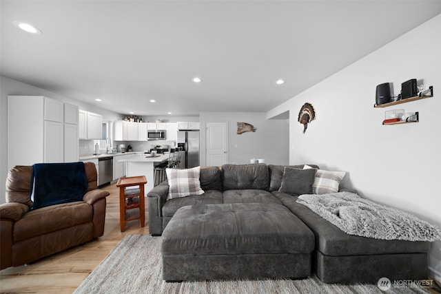 living room with sink and light hardwood / wood-style floors