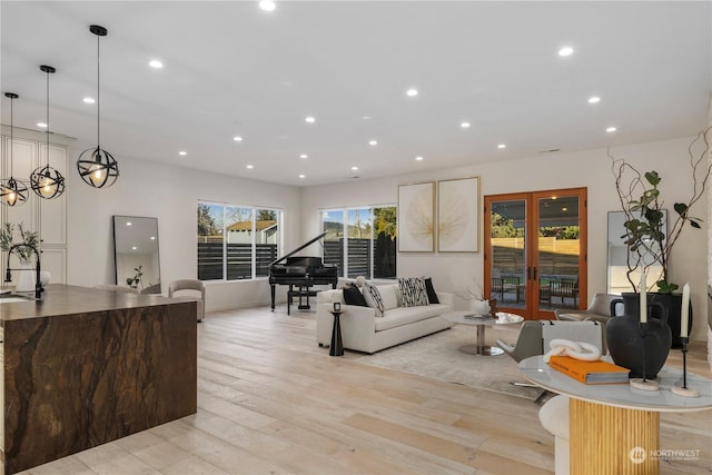 living room featuring sink, light hardwood / wood-style floors, and french doors