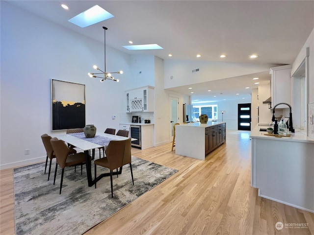 dining space featuring wine cooler, recessed lighting, visible vents, a chandelier, and light wood-type flooring