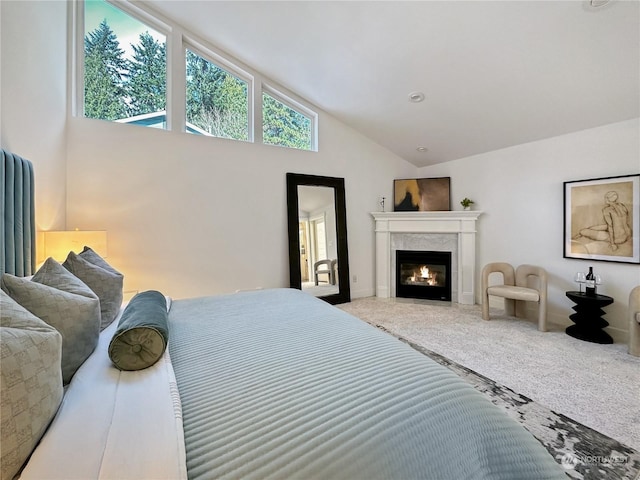 carpeted bedroom featuring high vaulted ceiling and a fireplace