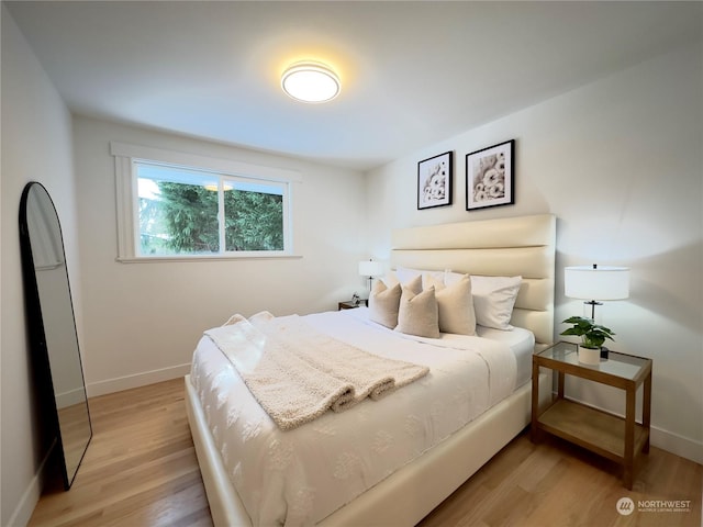 bedroom with light wood-type flooring and baseboards