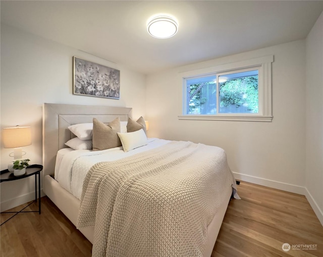 bedroom with baseboards and wood finished floors