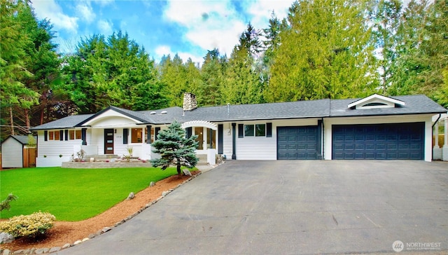 ranch-style home with aphalt driveway, a chimney, a shingled roof, a garage, and a front lawn