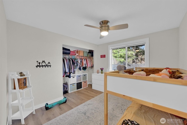 bedroom with wood-type flooring, ceiling fan, and a closet