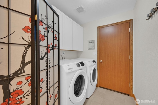 laundry room with separate washer and dryer and cabinets