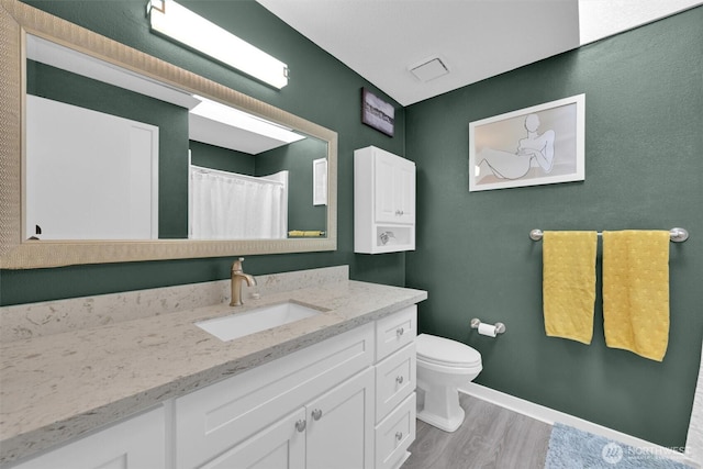 bathroom featuring vanity, hardwood / wood-style floors, a shower with shower curtain, and toilet