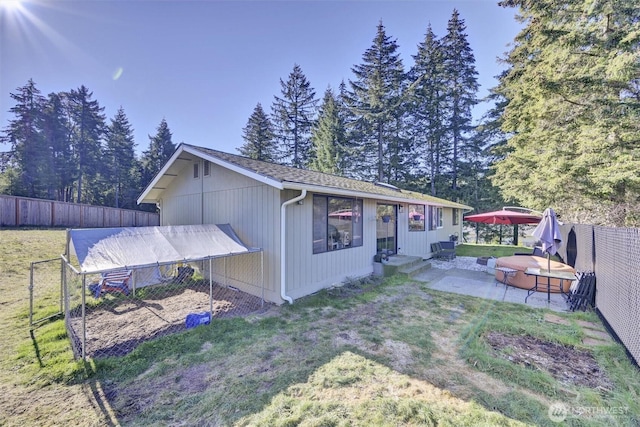 rear view of property with a yard and a patio