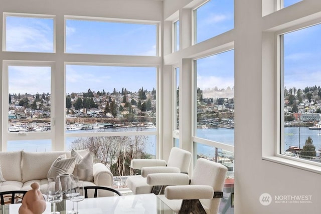 sunroom featuring a water view