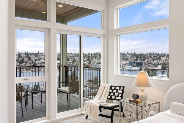 sunroom featuring a water view