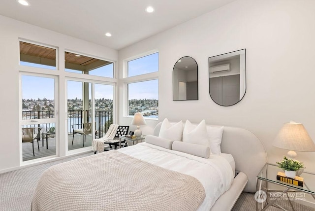 carpeted bedroom featuring access to exterior, a wall mounted AC, and a water view