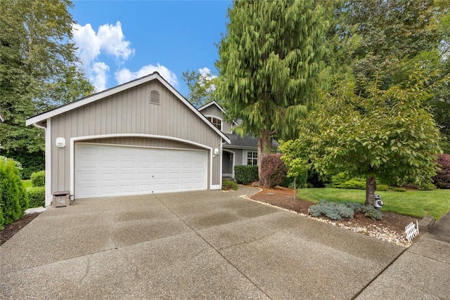 view of front of home with a garage, a front lawn, and concrete driveway