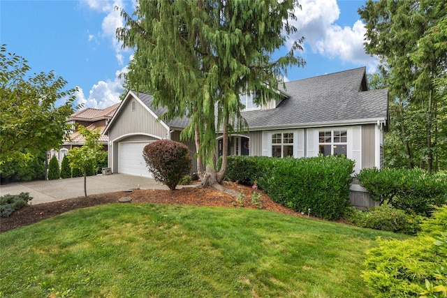 view of front of home featuring a garage, concrete driveway, and a front lawn