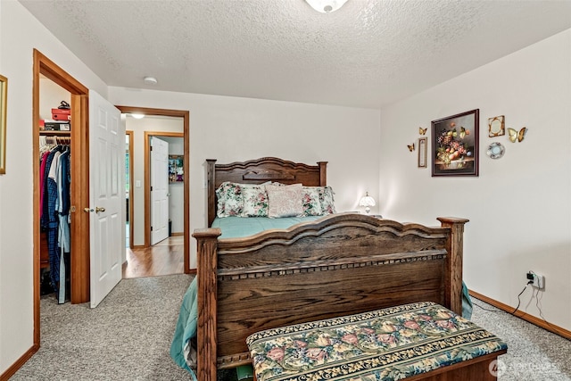 carpeted bedroom with a textured ceiling and baseboards