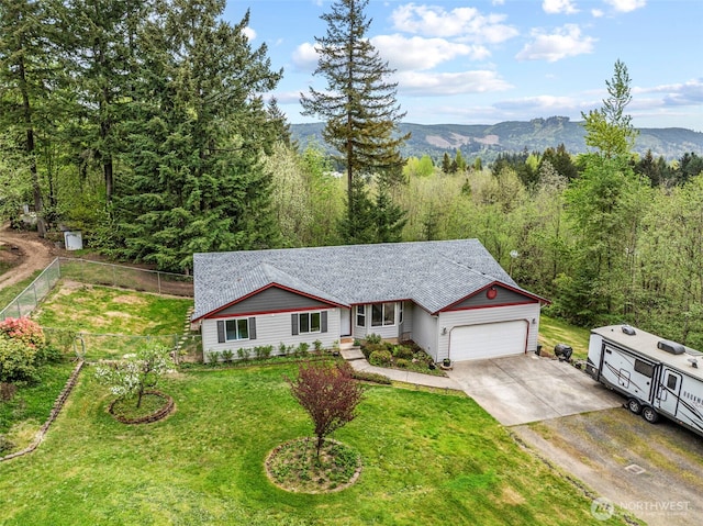 single story home featuring a front yard, fence, a wooded view, a garage, and driveway