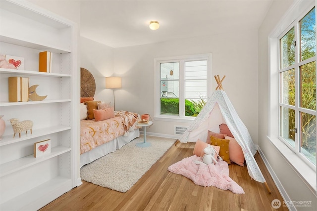 bedroom featuring visible vents, baseboards, and wood finished floors