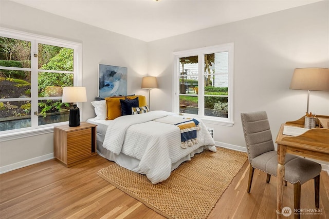 bedroom featuring light wood finished floors and baseboards