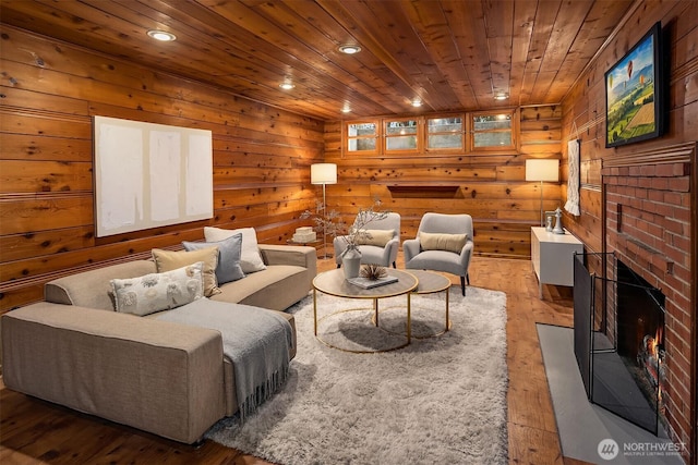 living room with a fireplace, recessed lighting, wood ceiling, wooden walls, and light wood-type flooring