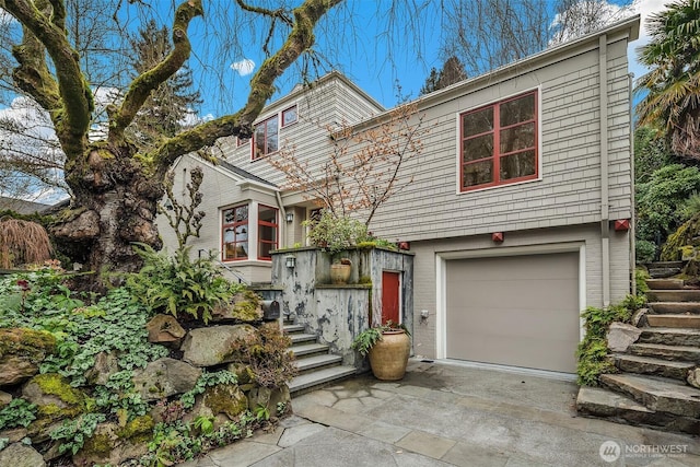 view of front of home featuring an attached garage, concrete driveway, and brick siding