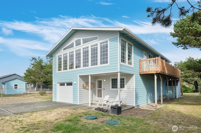 rear view of property featuring a garage and a lawn