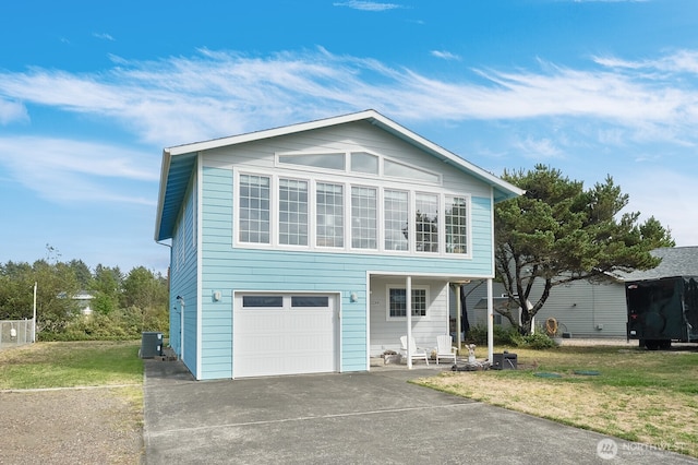 view of property featuring a garage, a front yard, and central air condition unit