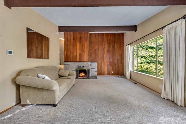 unfurnished living room with beamed ceiling, light colored carpet, and a textured ceiling