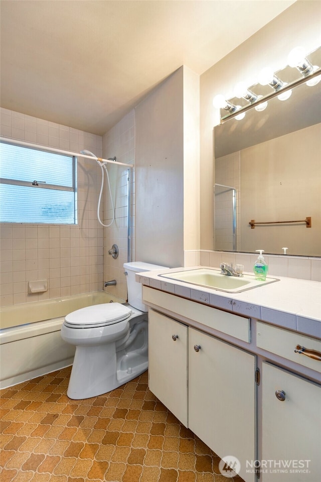 full bathroom featuring vanity, toilet, and tiled shower / bath