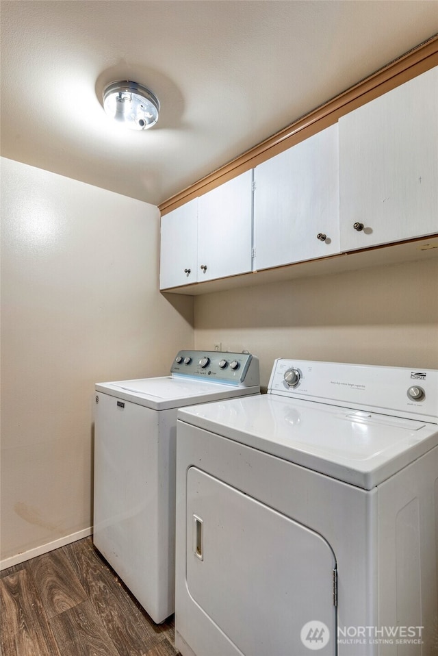 washroom with separate washer and dryer, dark hardwood / wood-style flooring, and cabinets