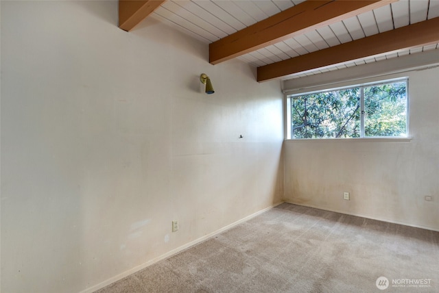 carpeted empty room featuring beamed ceiling and wooden ceiling