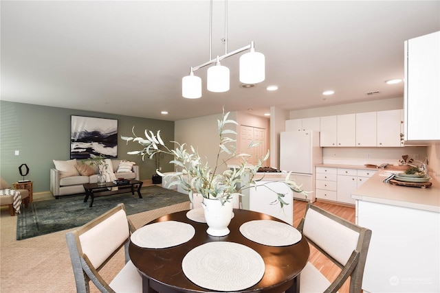 dining room featuring sink and light carpet