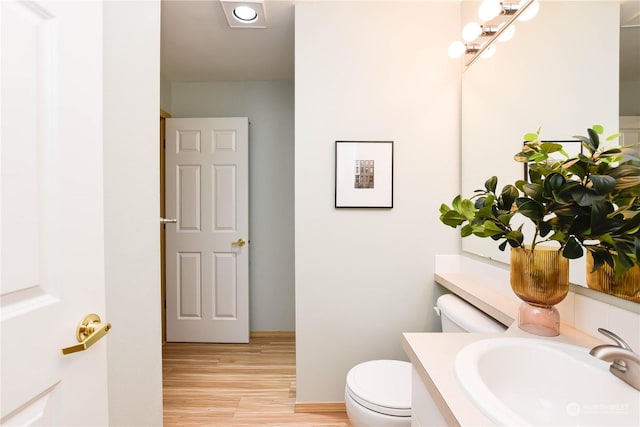 bathroom featuring hardwood / wood-style flooring, vanity, and toilet