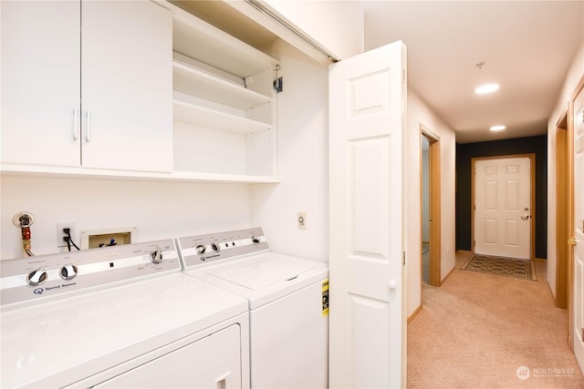 clothes washing area with light colored carpet and separate washer and dryer