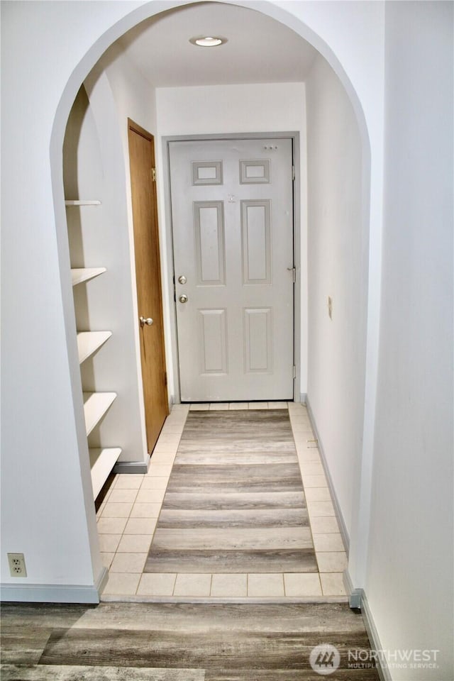 interior space featuring baseboards and light wood finished floors