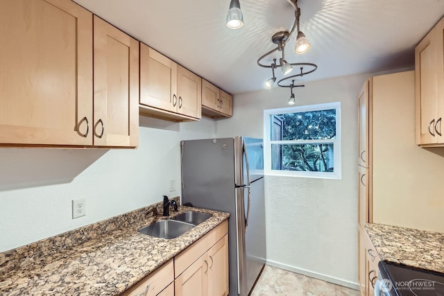 kitchen featuring stainless steel appliances, sink, light brown cabinets, and light stone counters