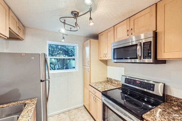 kitchen featuring appliances with stainless steel finishes, light brown cabinetry, light stone countertops, and sink