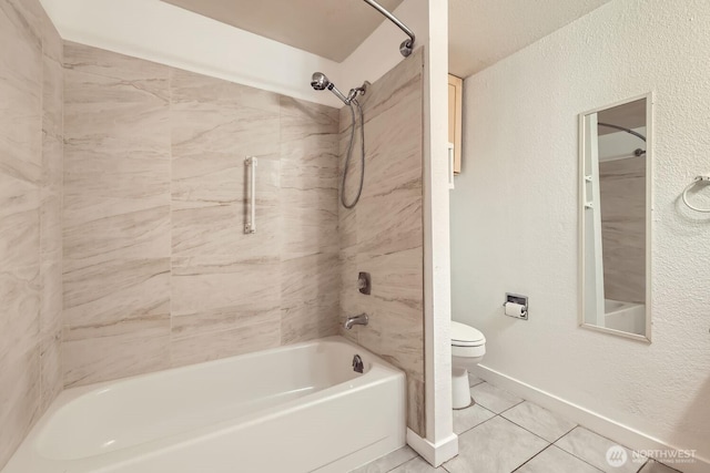 bathroom with tile patterned flooring, tiled shower / bath, and toilet