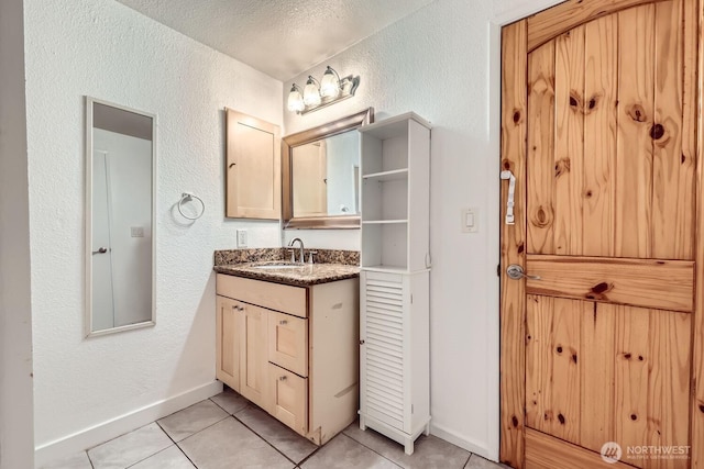 bathroom featuring tile patterned flooring, vanity, and a textured ceiling