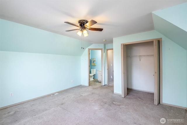 unfurnished bedroom with ceiling fan, a closet, lofted ceiling, and light carpet