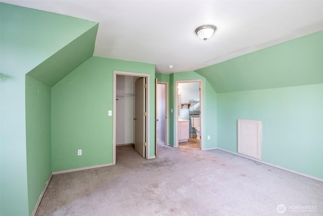 bonus room with light colored carpet and vaulted ceiling