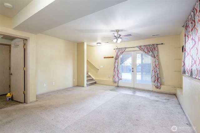 spare room with french doors, ceiling fan, and light carpet