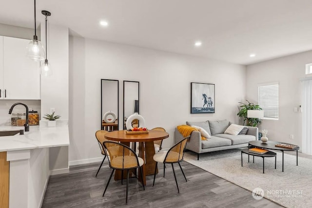 dining space with dark hardwood / wood-style flooring and sink