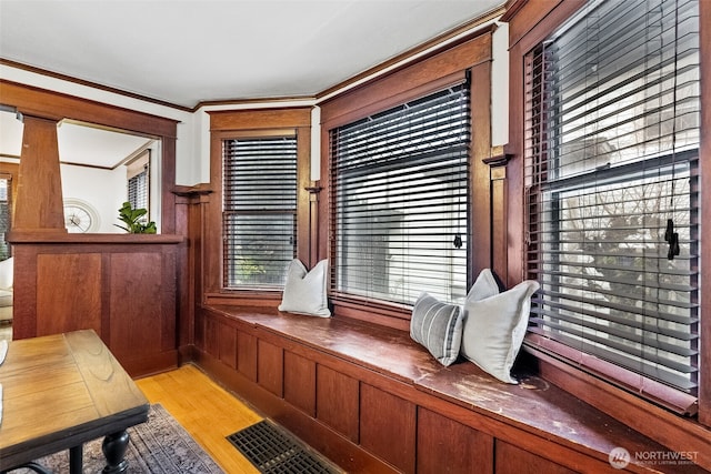 living area featuring light wood-type flooring and crown molding