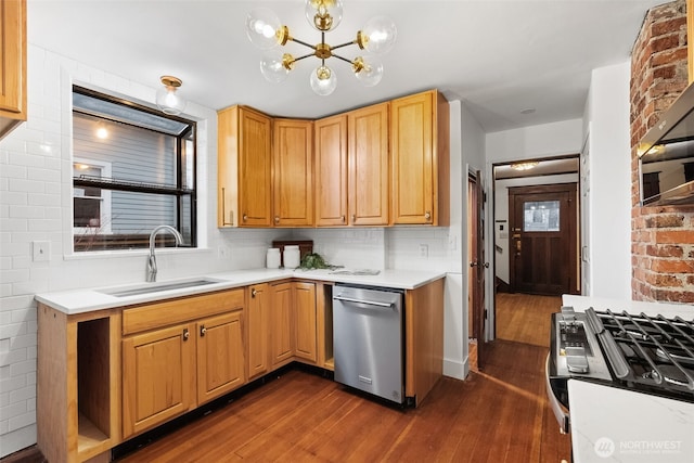 kitchen featuring appliances with stainless steel finishes, sink, backsplash, and dark hardwood / wood-style floors